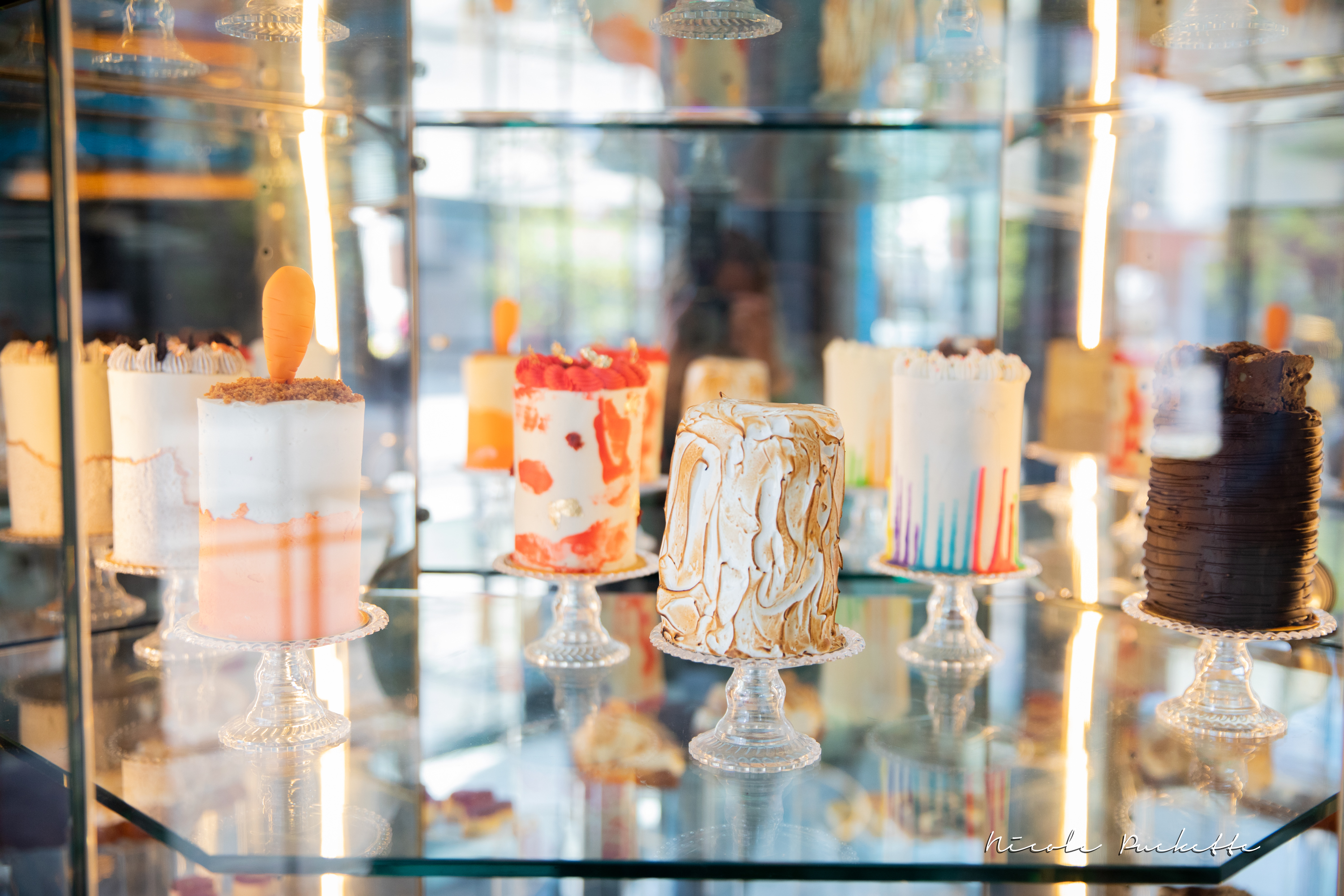 Signature Kakes cakes, one topped with lit birthday candles