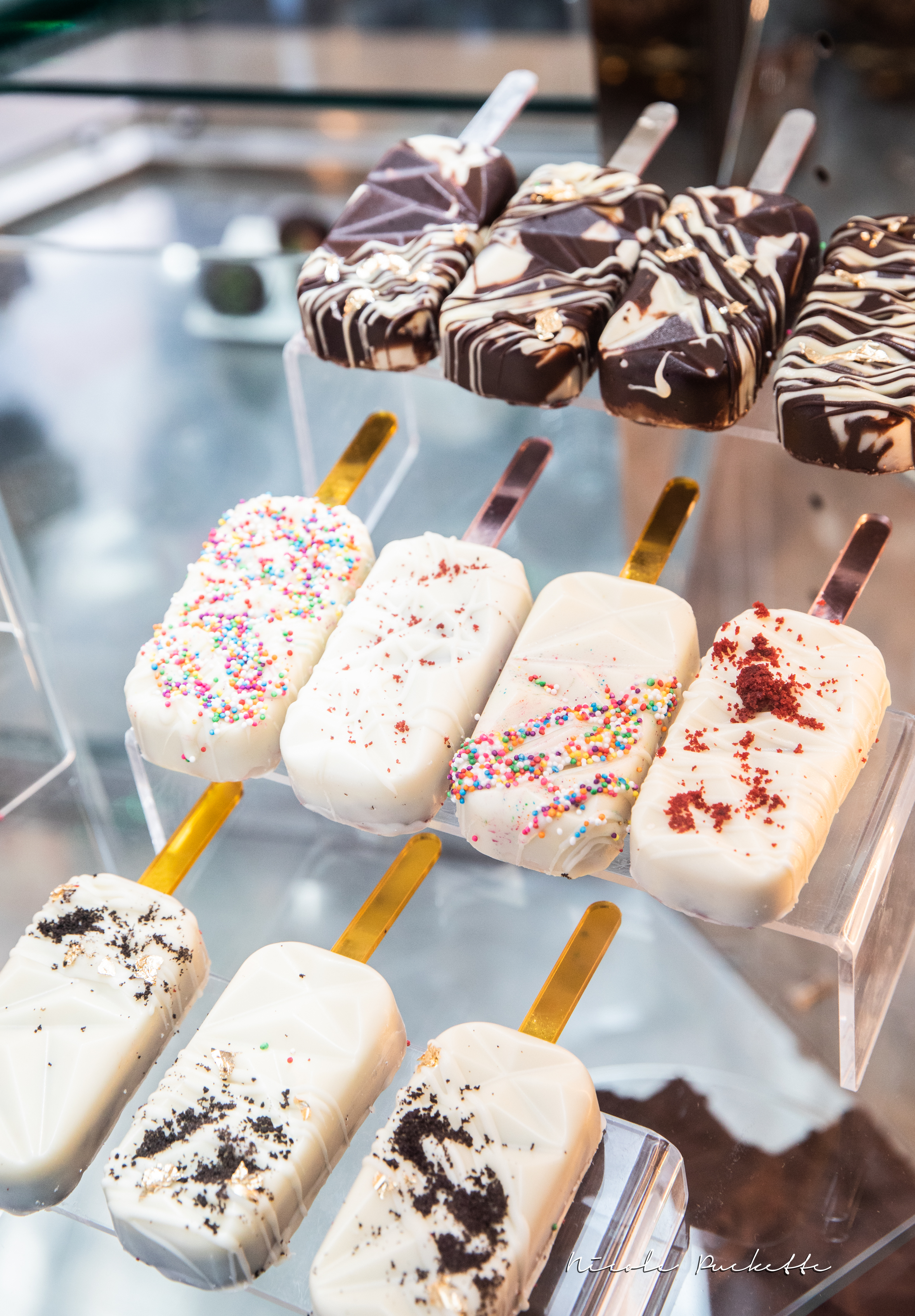 Chocolate-dipped Kakes cakesicles on a display stand
